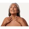 Boost Lab Edelweiss Neck Firming Serum – Lifestyle Model Mature woman with silver hair touching her smooth, firm neck after using Boost Lab Neck Firming Serum