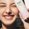 Haruharu Wonder Barrier Essence – Lifestyle Shot Glowing Skin Smiling model with glowing healthy skin holding Haruharu Wonder Black Rice Probiotics Barrier Essence – targets soothing, moisturising, plumping, firming and skin texture